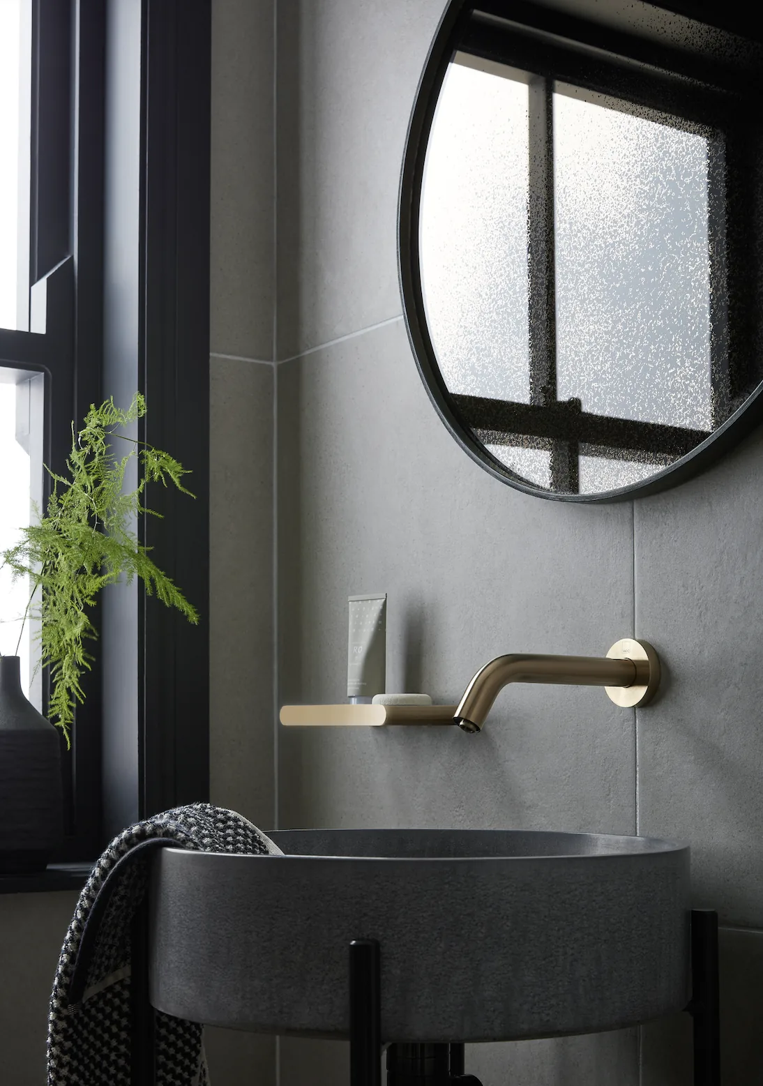 Omoi basin by a frosted window with a brass spout