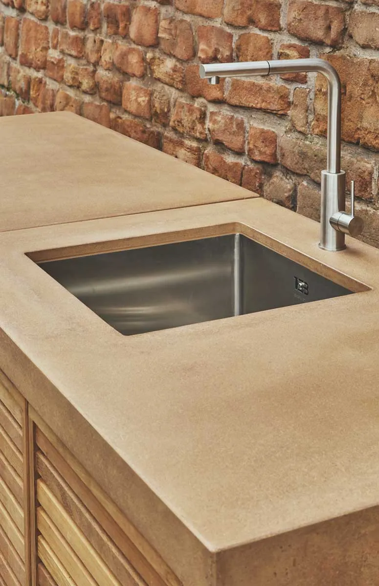 Concrete worktop with an inset steel sink and a mixer tap